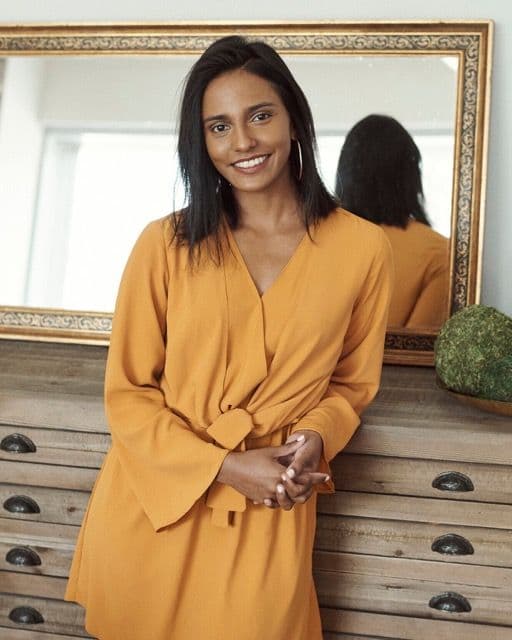 Shazeeda Bhola leaning against a cabinet with a mirror in the background.