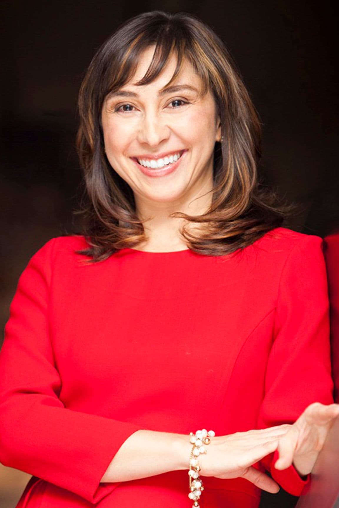 Headshot of Carolina Rogoll against a brown backdrop.
