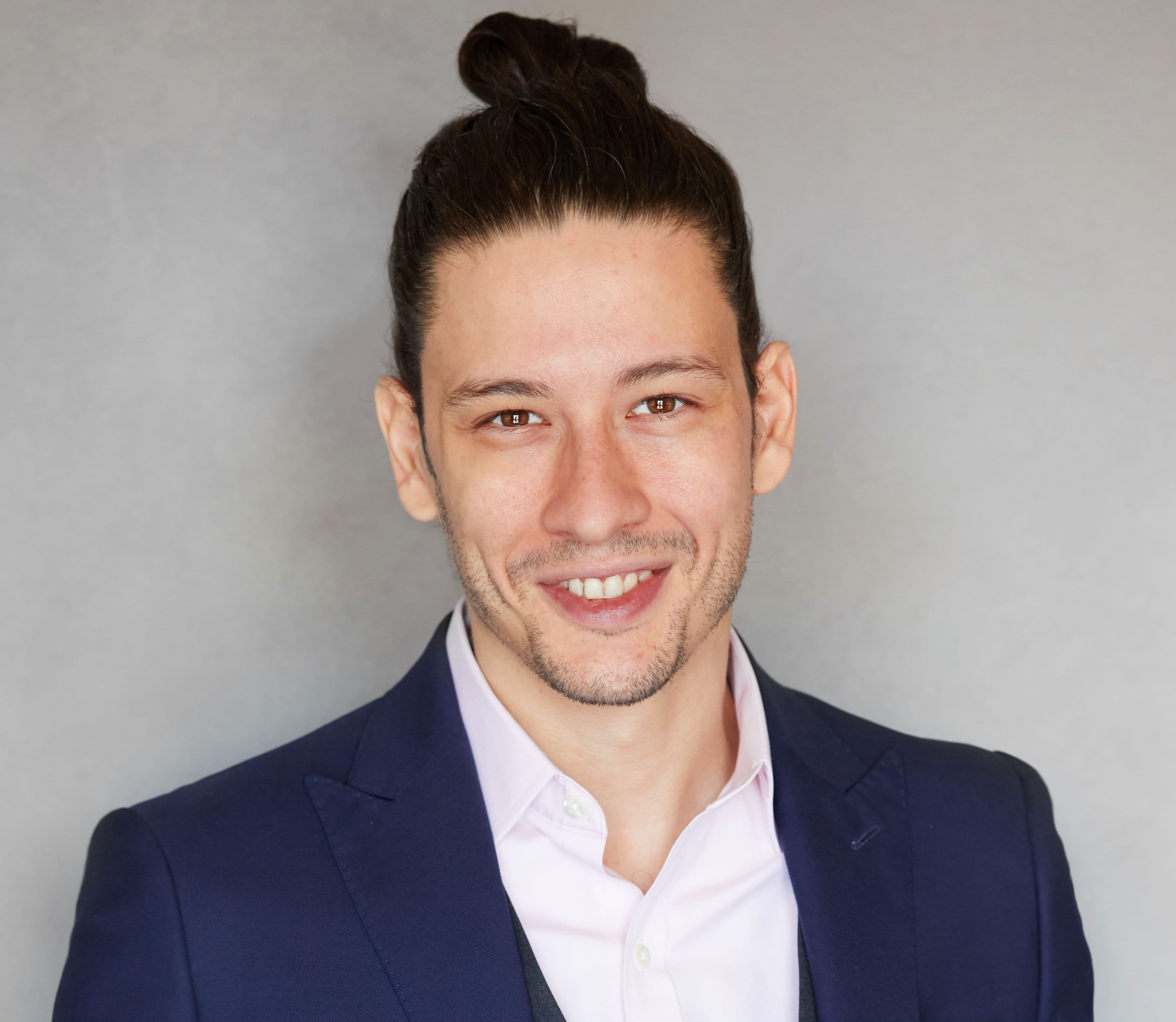 Headshot of Matei Schwartz smiling against a grey backdrop.